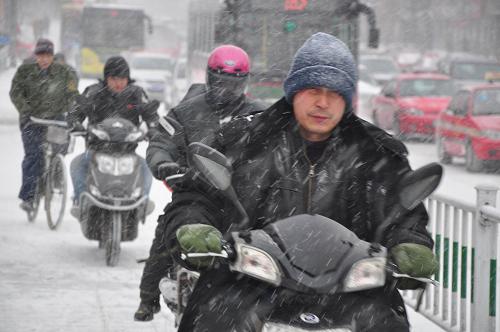 11月23日,牡丹江市街頭,幾位市民冒雪騎車出行。 當(dāng)日,黑龍江牡丹江氣象臺發(fā)布暴雪藍(lán)色預(yù)警,東北地區(qū)東部有小到中雪或雨夾雪,其中,黑龍江東南部、吉林東北部的部分地區(qū)有大雪,局地暴雪,對交通及農(nóng)牧業(yè)有較大影響。新華社發(fā)(張春祥 攝)