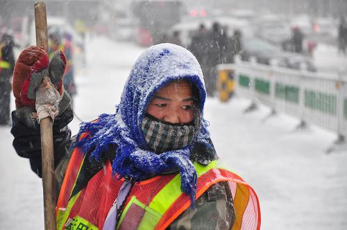 11月23日,牡丹江市街頭,一位環(huán)衛(wèi)工人冒雪清理積雪。新華社發(fā)(張春祥 攝)