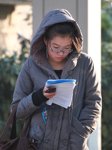 12月17日,在全國大學(xué)英語四級考試江蘇大學(xué)考點(diǎn)外,一名考生在進(jìn)行考前復(fù)習(xí)。新華社發(fā)(楊雨 攝)