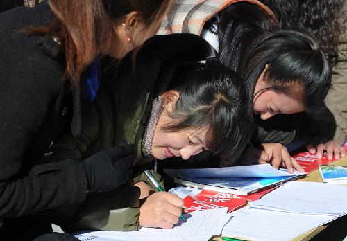 12月18日,在招聘會(huì)現(xiàn)場(chǎng),求職大學(xué)生在填寫招聘登記表。新華社記者 文濤 攝
