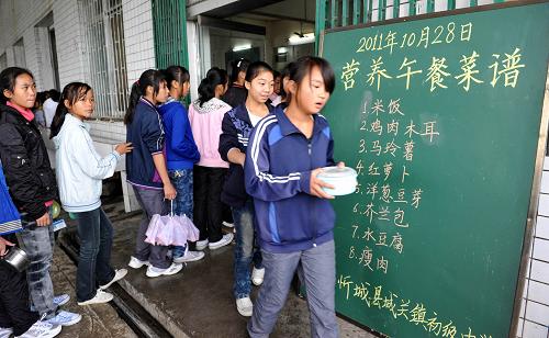 廣西將有40個(gè)縣116萬(wàn)中小學(xué)生享受“營(yíng)養(yǎng)午餐” 廣西忻城縣城關(guān)鎮(zhèn)中學(xué)的學(xué)生在學(xué)校食堂領(lǐng)取免費(fèi)“營(yíng)養(yǎng)午餐”(2011年10月28日攝)。 據(jù)悉,廣西日前在國(guó)家確定的農(nóng)村義務(wù)教育學(xué)生“營(yíng)養(yǎng)午餐”29個(gè)試點(diǎn)縣的基礎(chǔ)上,新增11個(gè)區(qū)級(jí)試點(diǎn)縣,這意味著廣西將有40個(gè)縣區(qū)、116萬(wàn)農(nóng)村中小學(xué)生能夠享受到“營(yíng)養(yǎng)午餐”的待遇。 新華社發(fā)(樊紹光 攝)