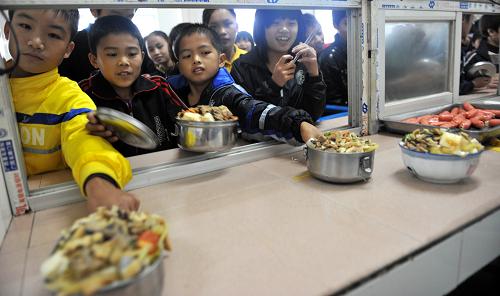 廣西忻城縣城關(guān)鎮(zhèn)中學(xué)的學(xué)生在學(xué)校食堂領(lǐng)取免費(fèi)“營(yíng)養(yǎng)午餐”(2011年10月28日攝)。 據(jù)悉,廣西日前在國(guó)家確定的農(nóng)村義務(wù)教育學(xué)生“營(yíng)養(yǎng)午餐”29個(gè)試點(diǎn)縣的基礎(chǔ)上,新增11個(gè)區(qū)級(jí)試點(diǎn)縣,這意味著廣西將有40個(gè)縣區(qū)、116萬(wàn)農(nóng)村中小學(xué)生能夠享受到“營(yíng)養(yǎng)午餐”的待遇。 新華社發(fā)(樊紹光 攝)