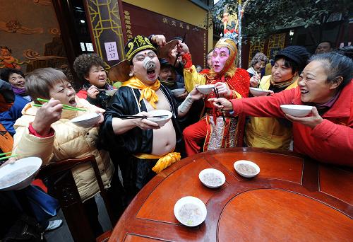 1月1日,在南京玄奘寺參加文藝演出的兩名“西游記”演員和市民一起喝臘八粥,他們的幽默舉動引起陣陣歡笑。2012年元旦恰逢傳統(tǒng)“臘八節(jié)”,南京玄奘寺、毗盧寺等城內(nèi)寺院準備了數(shù)萬份臘八粥,“過臘八,賀新年”活動吸引了眾多市民前來品粥祈福,歡度節(jié)日。新華社記者 孫參 攝