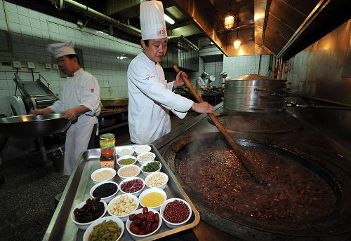 1月1日,北京全聚德和平門店大廚在熬制用江米、紅棗、蓮子等18種食材制作的臘八粥。新華社記者 張旭 攝