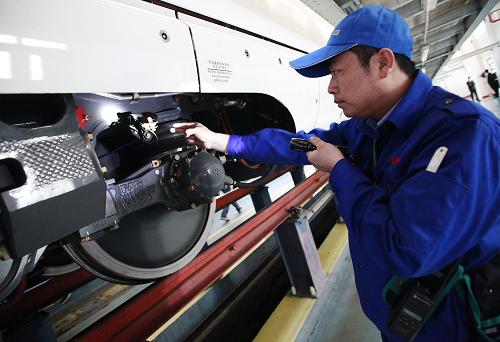 1月14日,北京動(dòng)車段,地勤機(jī)械師在對(duì)入庫(kù)的京滬高鐵動(dòng)車組運(yùn)用“必指、必看、必呼、必畫”的四必作業(yè)法進(jìn)行一級(jí)檢修作業(yè)。新華社發(fā)(王申 攝)
