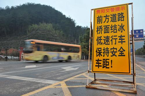 1月24日,車(chē)輛從貴州貴開(kāi)路的凝凍警示牌附近經(jīng)過(guò)。新華社記者歐東衢攝