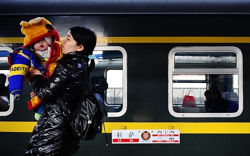 1月27日,一名懷抱小孩的乘客在西寧西客站進(jìn)站登車(chē)。新華社記者 張宏祥 攝