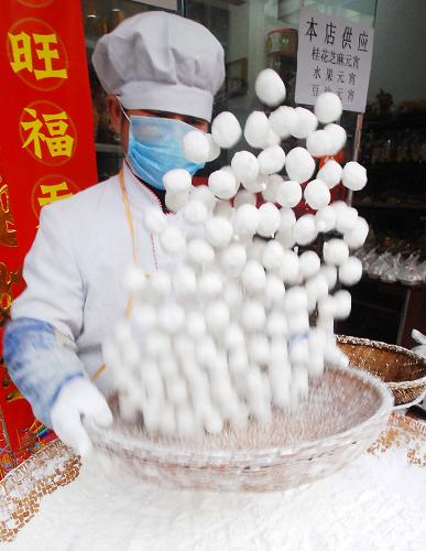 2月4日,在江西九江市一家元宵加工店,工作人員在用竹篩搖元宵。 新華社發(fā)(胡國(guó)林 攝)