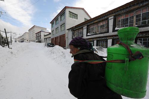 一位藏族婦女背水行走在被積雪覆蓋的西藏聶拉木縣城的街道上(2月11日攝)。2月7日至9日,西藏日喀則地區(qū)聶拉木縣遭遇特大暴風(fēng)雪襲擊,聶拉木縣城平均積雪厚度達1.5米。災(zāi)害造成全縣1萬余人不同程度受災(zāi),全縣交通、供電、供水、基礎(chǔ)設(shè)施及群眾的生產(chǎn)生或均受到不同程度影響。目前,當(dāng)?shù)卣腿罕娬谌﹂_展自救,群眾生產(chǎn)生活正在逐漸恢復(fù)。新華社記者 文濤 攝