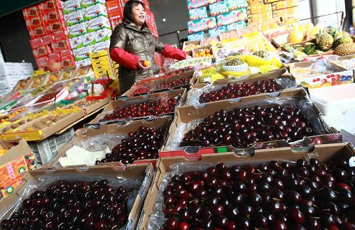 2月19日,上海農(nóng)產(chǎn)品中心批發(fā)市場(chǎng)內(nèi),一位進(jìn)口水果批發(fā)商在照看自己的攤位。新華社記者 裴鑫 攝