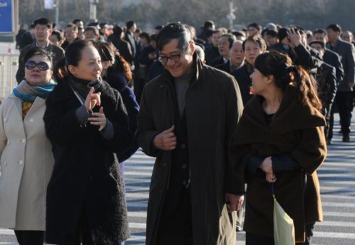 3月11日,全國政協(xié)十一屆五次會(huì)議在北京人民大會(huì)堂舉行第四次全體會(huì)議。這是抵達(dá)天安門廣場(chǎng)的邰麗華(左二)在翻譯的幫助下與委員交流。新華社記者 燕雁 攝