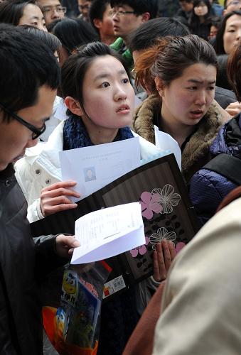 3月11日,在南京林業(yè)大學(xué)考點,參加公務(wù)員考試的考生們在考場分布表前查找自己的考場。當(dāng)日,江蘇省2012年考試錄用公務(wù)員公共科目筆試在全省14個考區(qū)、166個考點、7693個考場同時舉行,全省229450多名考生參加考試,考生人數(shù)為歷年來最多。2012年,江蘇省共招錄6748名公務(wù)員和參照管理單位工作人員,比2011年增加245名,招錄人數(shù)亦為歷年最多。其中,具有本科及以上學(xué)歷者仍然是招錄的主體。新華社記者 孫參 攝