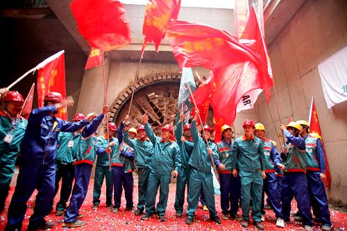 4月10日,承擔(dān)地鐵九號線盾構(gòu)任務(wù)的北京城建集團(tuán)工人慶賀穿湖成功。當(dāng)日10時(shí),隨著北京城建集團(tuán)“鉆石號”盾構(gòu)機(jī)刀盤從海軍醫(yī)院東南角的地鐵九號線豎井破洞而出,北京地鐵九號線盾構(gòu)實(shí)現(xiàn)南北大貫通。據(jù)悉,該段盾構(gòu)的貫通標(biāo)志著北京地鐵首次從礫巖層和卵石層等特殊地質(zhì)結(jié)構(gòu)穿越,成功破解了這項(xiàng)世界級難題。新華社發(fā)(黎方益 攝)