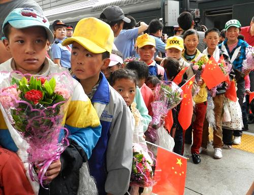 5月20日,在北京西站,來自西藏的先心病兒童們在海軍總醫(yī)院接站人員的帶領(lǐng)下走下火車。新華社發(fā) (王振 攝)