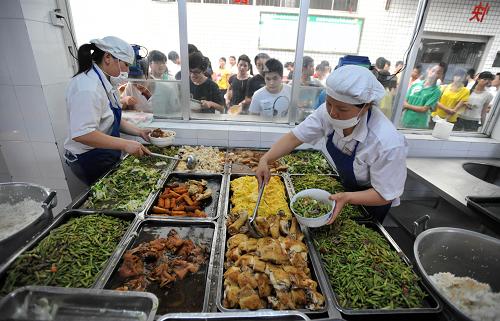 在廣西都安瑤族自治縣高級(jí)中學(xué)學(xué)生食堂,兩名工人給準(zhǔn)備參加高考的學(xué)生盛打品類豐富的晚餐(5月30日攝)。新華社記者 陸波岸 攝