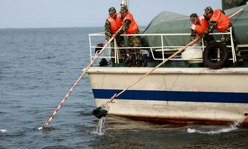 6月2日,遼寧海警二支隊(duì)官兵在丹東黃海海域用網(wǎng)抄清理海面上漂浮的垃圾。新華社發(fā)(桂子云 攝)