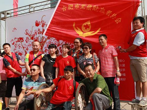 6月14日,姜小超與市民和志愿者一起在獻(xiàn)血宣傳板前合影。新華社記者 湯陽(yáng) 攝
