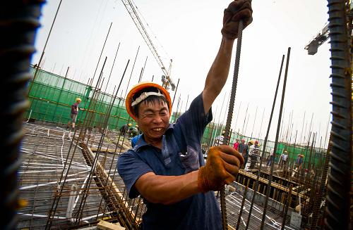 6月20日,一名建設(shè)者在10層高的操作面加固鋼筋。新華社記者 岳月偉 攝