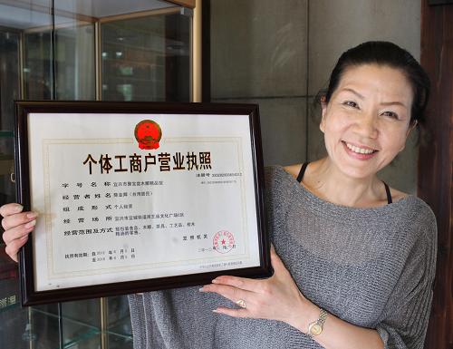 6月21日,店主陳金卿展示無(wú)錫宜興工商局發(fā)給她的個(gè)體工商戶營(yíng)業(yè)執(zhí)照。新華社發(fā)(丁煥新 攝)