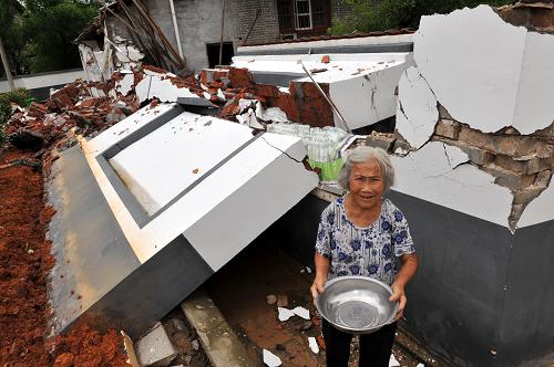 6月24日,窯頭鎮(zhèn)文溪村83歲的宋三英老人站在被洪水推倒的自家圍墻邊。新華社記者宋振平攝