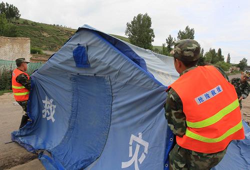 6月30日,武警官兵在新疆新源縣那拉提鎮(zhèn)哈拉蘇村搭建救災帳篷。新華社發(fā)(劉成剛 攝)