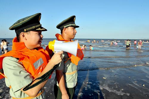 7月2日,長(zhǎng)樂(lè)市江田邊防派出所民警在下沙海域提醒學(xué)生和游人不要到危險(xiǎn)區(qū)域。新華社記者 張國(guó)俊 攝
