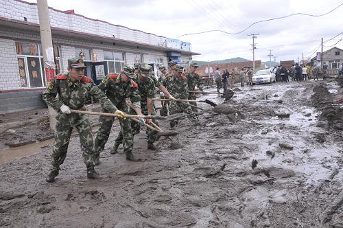 7月3日,武警邊防官兵在黑龍江省穆棱市下城子鎮(zhèn)新民村幫助村民清理洪水過后留下的淤泥。新華社發(fā)(張春祥 攝)