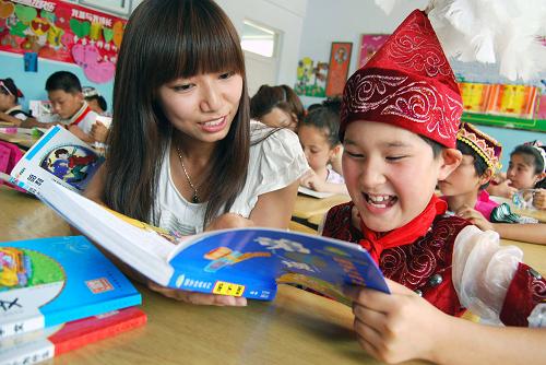 7月6日,江蘇大學(xué)學(xué)生姚瑤(前左一)在指導(dǎo)新疆霍城哈薩克族學(xué)生讀書。當(dāng)日,江蘇大學(xué)京江學(xué)院“雪蓮花”支教團隊的大學(xué)生志愿者來到新疆維吾爾自治區(qū)霍城縣水定鎮(zhèn)中心學(xué)校,開展為期20天的暑期支教活動,為當(dāng)?shù)馗髯逍∨笥阉腿坌?。新華社發(fā)(石玉成 攝)