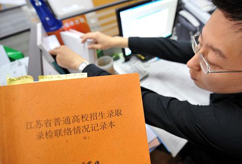 7月14日,江蘇省教育考試院高校招生錄取工作錄檢聯(lián)絡(luò)組的一名工作人員在核對(duì)相關(guān)資料。新華社記者 孫參 攝