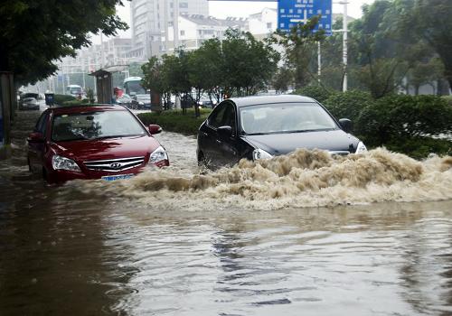 7月14日,江蘇鎮(zhèn)江遭暴雨襲擊,車輛在積水路段行駛。新華社發(fā)(封疆江 攝)