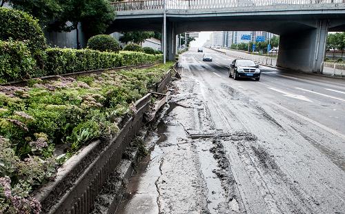 7月22日,曾出現(xiàn)嚴(yán)重積水的廣渠門橋西側(cè)路面還有少量淤泥。新華社記者 張宇 攝