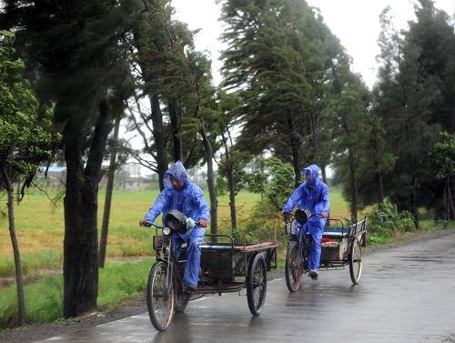 8月7日,兩位村民迎著大風騎車回家。新華社記者徐昱攝