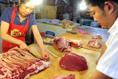 8月7日,在長春洪盛農(nóng)貿(mào)批發(fā)市場,一名牛肉攤主在向顧客出售牛肉。新華社記者 林宏攝