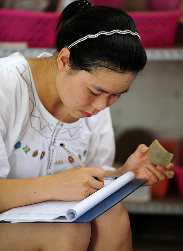 8月18日,一位文物工作者在對南水北調(diào)中線庫區(qū)出土的文物碎片進行登記,以便修復(fù)。新華社記者 郝同前 攝