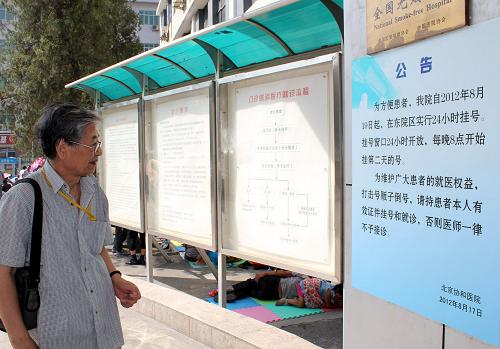 8月19日,一市民在閱讀北京協(xié)和醫(yī)院實(shí)行24小時(shí)掛號(hào)的公告。新華社發(fā)(王全超 攝)