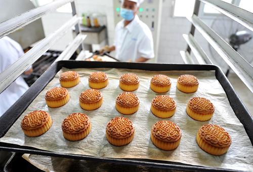 8月24日,在南京老字號(hào)“小蘇州”食品公司的月餅烘烤車(chē)間,按生產(chǎn)衛(wèi)生標(biāo)準(zhǔn)上崗的員工在向架子車(chē)上擺放剛出爐的月餅。近日,南京江寧區(qū)各食品企業(yè)進(jìn)入了月餅生產(chǎn)旺季,區(qū)工商、質(zhì)監(jiān)等部門(mén)強(qiáng)化月餅生產(chǎn)衛(wèi)生與質(zhì)量安全的監(jiān)控管理,督促相關(guān)廠家,在月餅原料進(jìn)口、包裝材料無(wú)害檢測(cè)、食品添加劑標(biāo)準(zhǔn)控制、生產(chǎn)過(guò)程衛(wèi)生無(wú)菌化等環(huán)節(jié)嚴(yán)格把關(guān),認(rèn)真執(zhí)行各項(xiàng)標(biāo)準(zhǔn)。區(qū)工商局還組織執(zhí)法人員,對(duì)月餅產(chǎn)銷(xiāo)企業(yè)開(kāi)展專(zhuān)項(xiàng)督查,確保消費(fèi)者購(gòu)買(mǎi)“放心月餅”。 新華社記者 孫參 攝