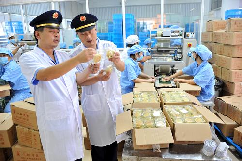 8月24日,在南京老字號(hào)“小蘇州”食品公司的月餅包裝車(chē)間,南京江寧區(qū)湖熟工商所派出巡查的工商執(zhí)法人員對(duì)月餅包裝進(jìn)行檢查。新華社記者 孫參 攝