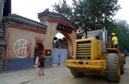 8月25日,北京電影制片廠明清街大門旁的圍墻上寫著“拆”字,一輛鏟車從門前經(jīng)過。新華社發(fā)(李文明 攝)
