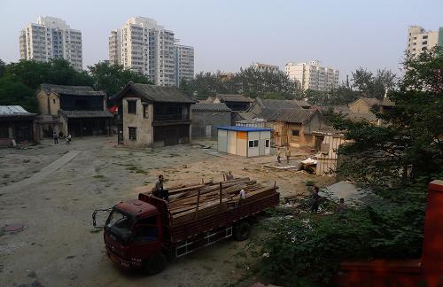 8月25日,工人們?cè)诒本╇娪爸破瑥S明清街內(nèi)進(jìn)行拆除施工。新華社發(fā)(李文明 攝)