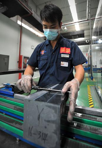 海南英利集團(tuán)的工作人員在檢查硅錠(8月22日攝)。新華社記者 郭程 攝