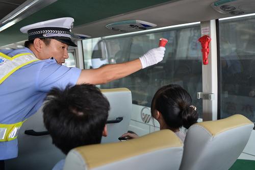 9月1日,山東省東營(yíng)交警支隊(duì)交警在東營(yíng)客運(yùn)總站的一輛大巴上向乘客現(xiàn)場(chǎng)演示逃生錘的使用方法。新華社記者 潘超越 攝