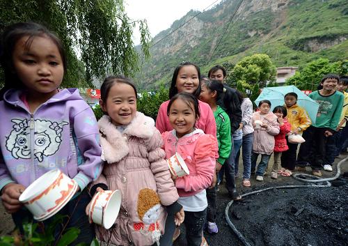 9月16日,地震重災(zāi)區(qū)的小朋友在排隊(duì)打飯。新華社記者 楊宗友 攝