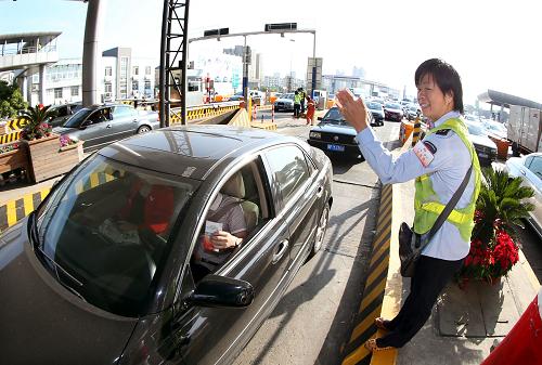9月30日,京滬高速江橋收費(fèi)站工作人員在崗?fù)ね獍l(fā)放通行卡。當(dāng)日是《重大節(jié)假日免收小型客車通行費(fèi)》正式實(shí)施第一天。據(jù)統(tǒng)計(jì),京滬高速江橋收費(fèi)站車流比平常增加了六成多,但在上海交警等部門的統(tǒng)一調(diào)度下,車輛有序出行。新華社記者 凡軍 攝