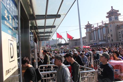 10月5日,抵達(dá)北京火車站的旅客進(jìn)入地鐵站。新華社發(fā)(王全超 攝)