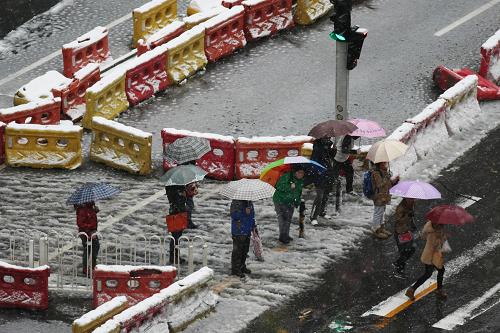 11月4日,路人撐傘在北京幸福大街附近過馬路。 11月3日夜晚開始,北京迎來一場(chǎng)雨夾雪天氣,并伴有大幅降溫,給市民出行帶來不便。 新華社發(fā)(李方宇 攝)