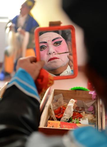 “莊戶劇團(tuán)”樂鄉(xiāng)村 11月24日,村民演員在演出前化裝。 農(nóng)忙已過,山東鄒平縣西黃村的“莊戶劇團(tuán)”又開始忙碌起來,十里八鄉(xiāng)的村莊都紛紛邀請她們?nèi)パ莩觥N鼽S村業(yè)余劇團(tuán)1998年正式成立,由村民們自發(fā)、自愿結(jié)合,不計(jì)任何報(bào)酬。十幾年來,業(yè)余劇團(tuán)的演職人員不斷變化,但為村民義務(wù)演出的傳統(tǒng)和對民間戲曲的喜愛一直沒改變。現(xiàn)在,西黃村業(yè)余劇團(tuán)的成員們已經(jīng)整理、編排傳統(tǒng)劇目37出,每年為村民演出40余場次。 據(jù)山東省文化部門統(tǒng)計(jì),山東目前有農(nóng)村民辦劇團(tuán)5200個(gè),這些“莊戶劇團(tuán)”根植鄉(xiāng)村大地,豐富繁榮了農(nóng)村文化生活。 新華社記者 朱崢攝