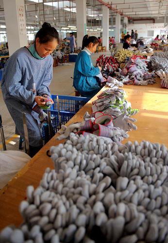 12月5日,在廣西欽州市臨海工業(yè)園一皮革加工廠,工人在生產(chǎn)出口歐美的皮手套。新華社記者 張愛林 攝