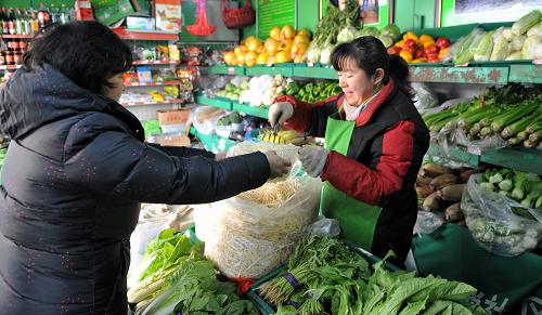 12月11日,一位豐臺街道永善社區(qū)的居民在社區(qū)內(nèi)的便民果蔬店買菜。新華社記者 李欣 攝