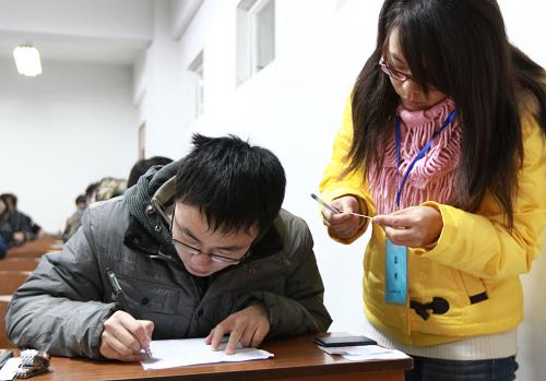 12月22日,在全國(guó)大學(xué)英語(yǔ)四級(jí)考試江蘇大學(xué)考點(diǎn),監(jiān)考老師在核對(duì)考生身份。新華社發(fā)(楊雨 攝)