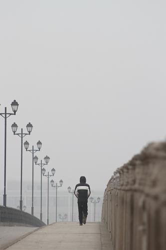 1月24日,一名行人在霧霾籠罩的江蘇常州街頭出行。 新華社發(fā)(陳暐 攝)